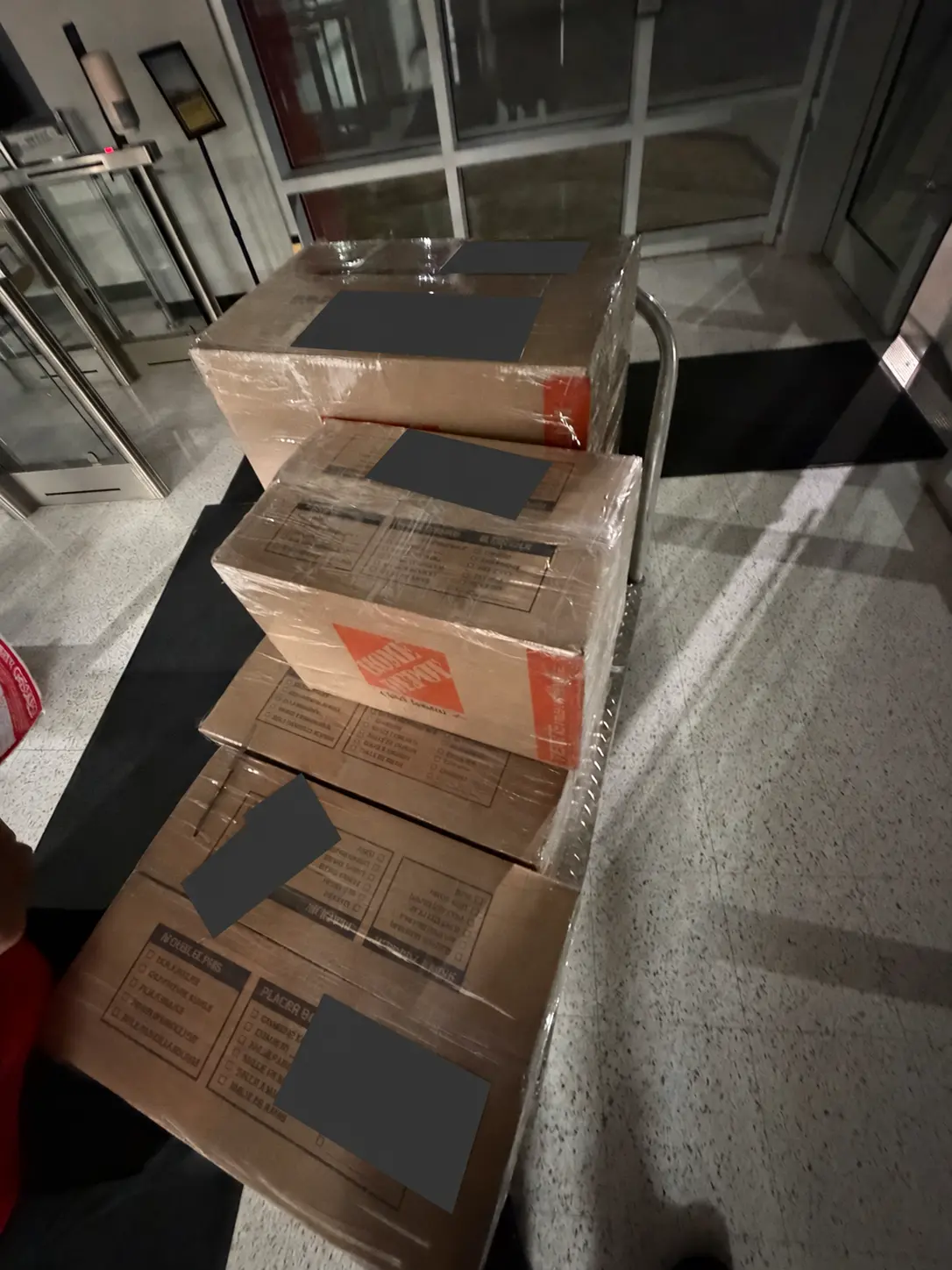 Wrapped shipping cartons on a carrier cart with shipping labels fully covered