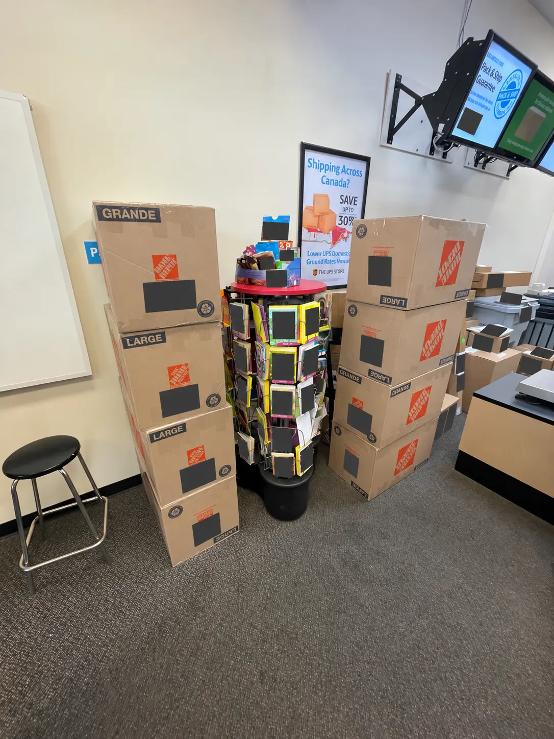 Stacked shipping cartons at a carrier location with private details concealed