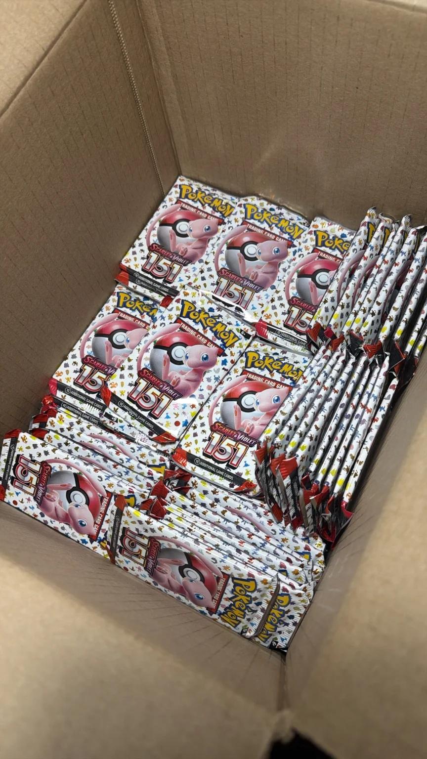 English Pokémon Scarlet & Violet 151 booster packs arranged inside a cardboard carton