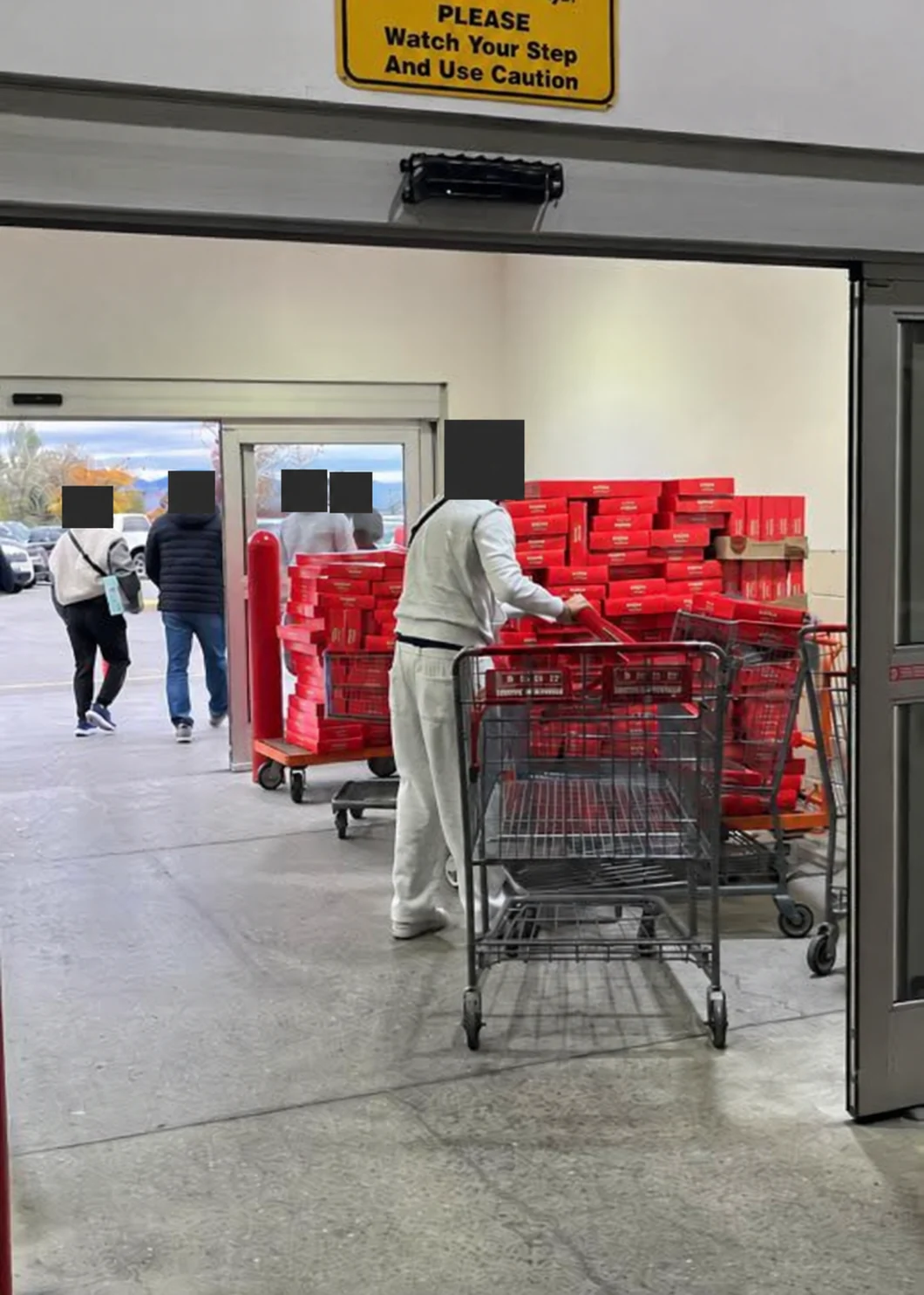 Stock collection with carts of sealed products; faces concealed for privacy